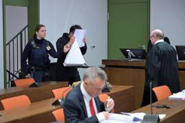Un acusado se cubre el rosto al llegar a un juicio a una red de hombres en su mayoría chinos, organizados en grupos de chat para aconsejarse sobre cómo drogar y violar a mujeres en su mayoría chinas, en Múnich.