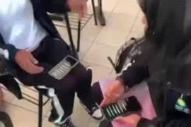 En las imágenes se aprecia a dos estudiantes sentados en sus pupitres frente a varias líneas de un polvo blanco colocadas sobre teléfonos celulares.