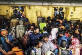 Pasajeros se empujan para abordar un tren en la estación de Nueva Delhi, India, el sábado 15 de febrero de 2025.