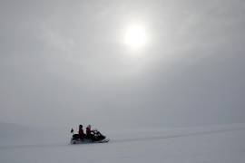 Fotografía cedida por Imagen Chile que muestra a dos visitantes en una moto para el hielo en el Glaciar Unión. Este sábado un eclipse solar podrá ser visto en su plenitud desde la Antártida. EFE/ Felipe Trueba/Cortesía Imagen Chile