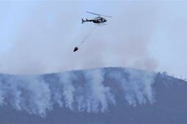 Helicóptero descarga agua sobre las llamas sobre Sierra de Huachichil