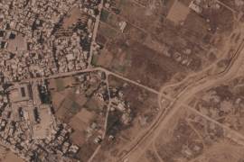 Un tramo de una barrera de tierra construida por el ejército israelí, desde el lado derecho y hacia abajo, en el centro de la Franja de Gaza. A la izquierda, el campo de refugiados de Maghazi, y al otro lado casas demolidas.