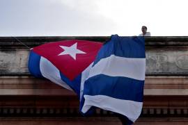 Un joven coloca una bandera cubana en el techo de una de las facultades de la Universidad de La Habana, donde estudiantes participaron en un acto para ver en una pantalla el discurso del canciller cubano Bruno Rodríguez en la ONU y la votación en contra del Bloqueo de EE.UU. contra Cuba.
