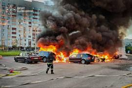 En esta imagen, proporcionada por el Servicio Ucraniano de Emergencias, bomberos intentan sofocar las llamas en unos autos tras un ataque con drones rusos en la región de Kiev, Ucrania.