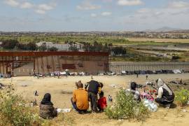 Fotografía general donde se observa a migrantes en un campamento junto al muro fronterizo, el 9 de mayo de 2023, en Tijuana, Baja California.