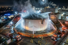 Bomberos del condado de Orange mantienen el enfriamiento con agua sobre un tanque de metacrilato de metilo (MMA) agrietado en la planta de GKN Aerospace para evitar una explosión.