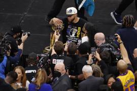 El escolta de los Golden State Warriors, Stephen Curry, posa con el Trofeo Larry O’Brien y el Trofeo MVP de las Finales de la NBA.