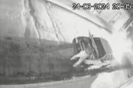 La cámara de video-vigilancia captó el momento en que un sujeto roba la batería de un coche.
