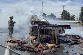 Elementos del cuerpo de bomberos de Ramos Arizpe trabajan arduamente para controlar el incendio que consumió por completo un camión de carga en la carretera Saltillo-Monterrey.