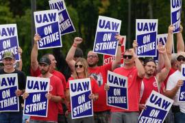 Miembros de United Auto Workers sostienen carteles de piquete cerca de una planta de ensamblaje de General Motors en Delta Township, Michigan.