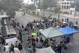 Estudiantes del TecNM resguardan el bloqueo sobre la Carranza con carpas improvisadas ante la lluvia.