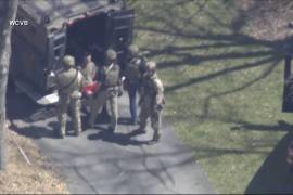 Esta imagen tomada de un video proporcionado por WCVB-TV muestra a Jack Teixeira, en camiseta y pantalones cortos, siendo detenido por agentes tácticos armados el jueves en Dighton, Massachusetts.