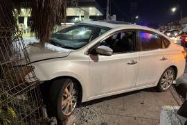 El Nissan Sentra quedó sobre la banqueta tras impactar la base del estacionamiento.