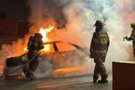 Los bomberos trabajaron para sofocar el incendio del vehículo en el estacionamiento de una tienda de conveniencia.