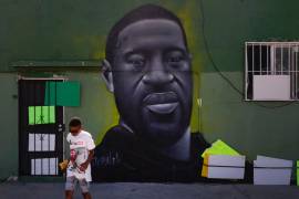 Benjamin Jackson III, de 10 años, pasa junto a un mural que representa a George Floyd en el barrio Watts de Los Ángeles, el martes 9 de junio de 2020. AP/Jae C. Hong