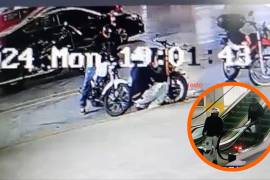 Uno de los presuntos ladrones, portando un casco blanco, manipuló la motocicleta en el estacionamiento de la plaza comercial antes de sustraerla.