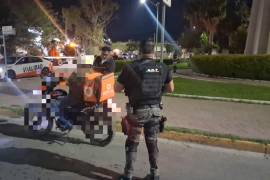 Agentes de Tránsito y del Grupo de Reacción realizan la revisión de una motocicleta durante un operativo nocturno.