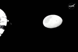 En esta imagen de un video proporcionado por la NASA, se ve la Luna desde una cámara ubicada fuera de la nave espacial Orión mientras los astronautas de Artemis II saludan a los astronautas del Apolo 13.