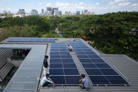 Un equipo de instaladores solares instaló un nuevo sistema de paneles solares en el tejado de una vivienda en Manila, Filipinas.