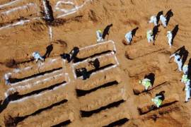 Las autoridades publicaron imágenes que mostraban a agentes de policía y médicos excavando en la arena y recuperando cadáveres envueltos en mantas. FOTO: