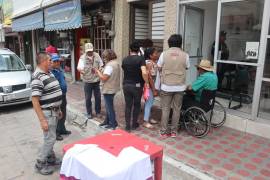 Empleados del Banco del Bienestar asistiendo a beneficiarios dentro de la sucursal en Saltillo, asegurando un proceso de entrega de pensiones sin problemas.