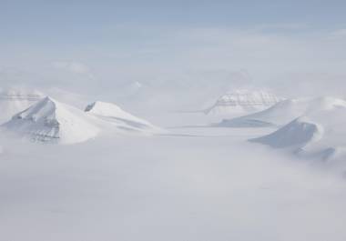 Vista aérea desde un vuelo entre los asentamientos de Ny-Alesund y Longyearbyen del accidentado terreno ártico del archipiélago noruego de Svalbard, al oeste del norte de Groenlandia.