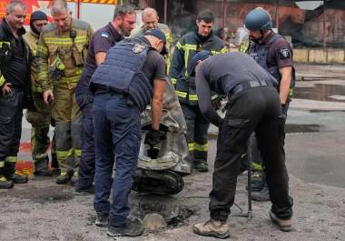 Bomberos examinan un fragmento de un misil ruso tras los ataques aéreos a un almacén de alimentos en Kiev, Ucrania, el miércoles 5 de agosto de 2026.