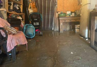 Muebles, colchones y ropa empapados dentro de la casa de la familia, mostrando los estragos causados por la lluvia.