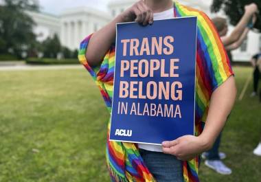 Una persona sostiene un cartel que dice “Las personas trans pertenecen a Alabama” en una protesta frente al Capitolio estatal de Alabama en Montgomery.