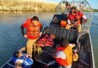 La familia hondureña es atendida por personal del INM tras ser llevada a tierra firme.