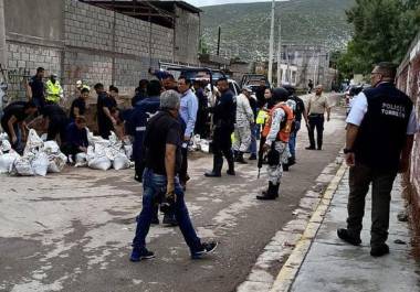 Elementos de la Guardia Nacional y bomberos colaboraron en el llenado de costales con arena para contener las inundaciones en la colonia Santiago Ramírez.