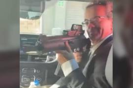 En un video se observa al ahora exdiplomático Jon Benjamin con un arma de alto poder.