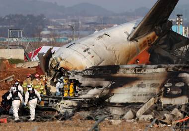 Los bomberos trabajan en los restos del avión Jeju Air en el Aeropuerto Internacional de Muan, 29 de diciembre de 2024. Las autoridades elevaron a 179 la cifra oficial de muertos en el accidente del avión comercial que se salió de la pista y chocó contra un vallado tras aterrizar.