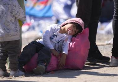 Un niño descansa sobre una bolsa mientras es procesado por la Patrulla Fronteriza de Estados Unidos entre las dos vallas fronterizas en la frontera sur de Estados Unidos con México, en San Diego, California.