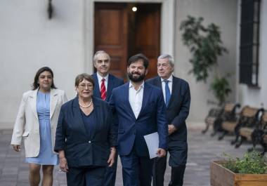 El mandatario Gabriel Boric (c), junto a la expresidenta Michelle Bachelet (2i) caminando en el palacio de La Moneda, en Santiago, Chile.