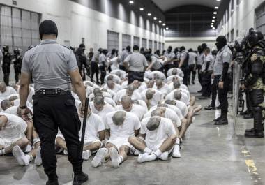 En esta fotografía proporcionada por la oficina de prensa de la presidencia de El Salvador, guardias penitenciarios trasladan a presuntos pandilleros venezolanos, deportados de Estados Unidos, al Centro de Confinamiento del Terrorismo (CECOT), en Tecoluca, El Salvador. FOTO: