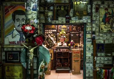 Ofrendas de flores, velas, fotos y billetes de dólar en un santuario dedicado a Jesús Malverde, un “narcosanto”, en Culiacán.