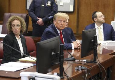 El expresidente estadounidense Donald Trump (centro) espera el inicio de una audiencia en el Tribunal Penal de la ciudad de Nueva York, el 15 de febrero de 2024.