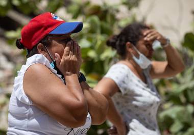 Personas reaccionan durante las labores de búsqueda en La Guaira, Venezuela.