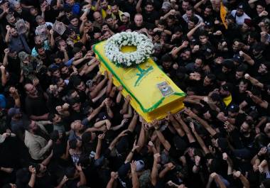 Miembros de Hezbolá llevan el ataúd de su compañero que murió cuando explotó un dispositivo portátil, durante una procesión fúnebre en los suburbios del sur de Beirut.