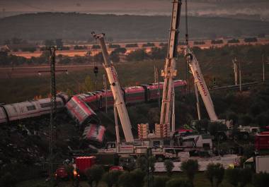 Cranes lift wrecked train carriages as rescuers search for victims following a collision between two trains in Urda, Spain, Thursday, Oct. 29, 2026. (AP Photo/Manu Fernandez)