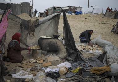 Mona Al-Zebda, desplazada de Ciudad de Gaza, hornea pan en un campamento de tiendas para palestinos desplazados en Muwasi, Rafah, sur de la Franja de Gaza, lunes 24 de febrero de 2025. FOTO: