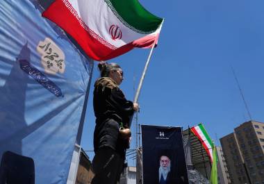 Una mujer ondea una bandera iraní durante una marcha progobierno, donde se ve la imagen del fallecido líder supremo iraní Alí Jamenei, asesinado en ataques de EU e Israel el 28 de febrero.