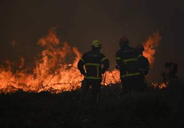 Bomberos rocían agua en un incendio forestal cerca de Lacanau, en el suroeste de Francia, el sábado 25 de julio de 2026.