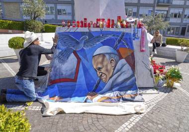 El pintor mexicano Roberto Márquez coloca un retrato del papa Francisco afuera del Hospital Gemelli de Roma,, donde el pontífice se encuentra hospitalizado. FOTO: