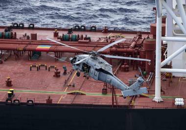 Fotografía difundida en la cuenta oficial en X @DeptofWar del Departamento de Guerra de Estados Unidos de uno de sus helicópteros interceptando un buque petrolero en el océano Índico.