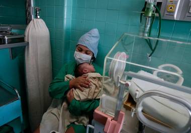 En medio de los cortes de energía que paralizan a Cuba, una enfermera sostiene a un bebé en el Hospital Pediátrico William Soler.
