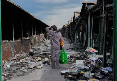 Una mujer se lamenta al ver libros calcinados tras un incendio en el mayor mercado de libros del país, provocado por un ataque con misiles rusos, el 19 de agosto de 2026, en Kiev, Ucrania.