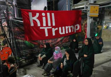 Varias mujeres se sientan junto a una pancarta que dice en inglés “Maten a Trump” durante una manifestación progubernamental, el viernes 17 de julio de 2026, en Teherán, Irán.
