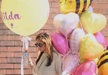 Una mujer lleva globos al funeral de Matilda, de 10 años, víctima del tiroteo masivo en Bondi Beach, cuyo apellido se mantiene en reserva a petición de su familia, en Sídney.